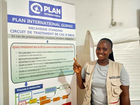 Femme présentant panneau d'informations de Plan International